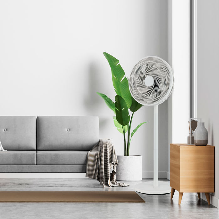 Ventilador pedestal 3 en 1 Bestherm en un living, junto a una planta y un mueble de madera