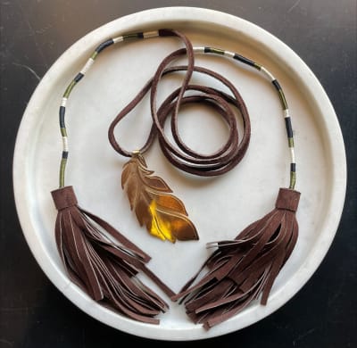 COLLAR DE GAMUZA, HILOS TEJIDOS Y DIJE DE PLUMA