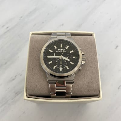 Reloj Hombre Michael Kors plateado fondo negro tres relojes sin numeros1