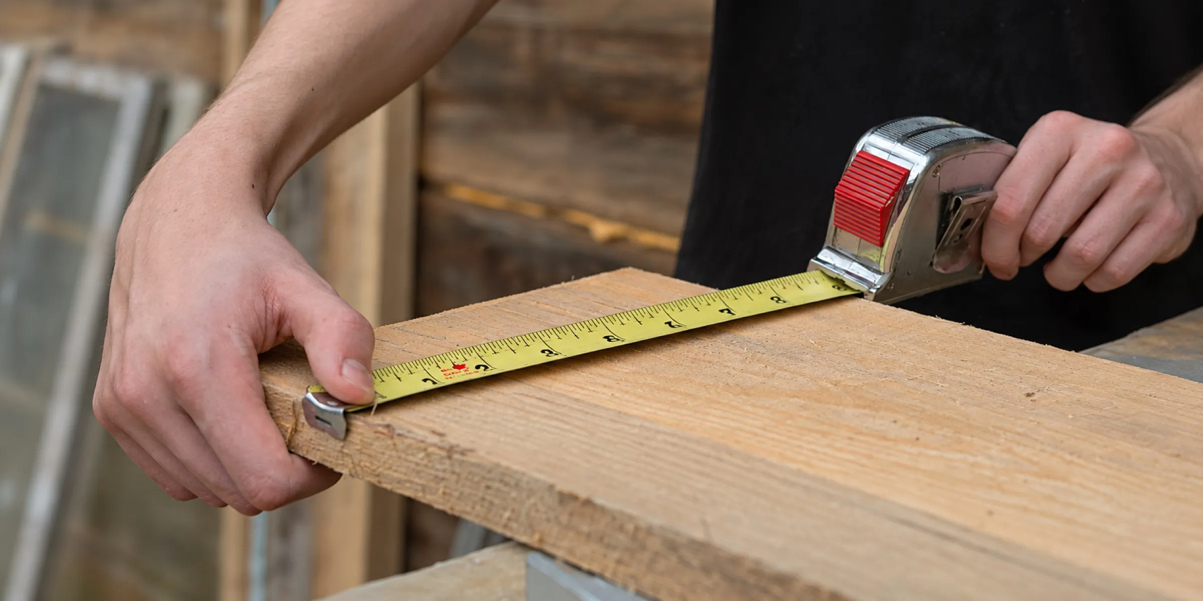 Medición de una tabla de madera con cinta métrica