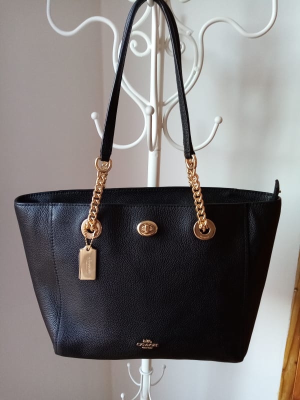 CARTERA COACH NEGRA CON DORADO